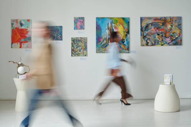 Blurred motion of people in art gallery Blurred motion of people passing through the paintings on the wall in art gallery people sculpture stock pictures, royalty-free photos & images