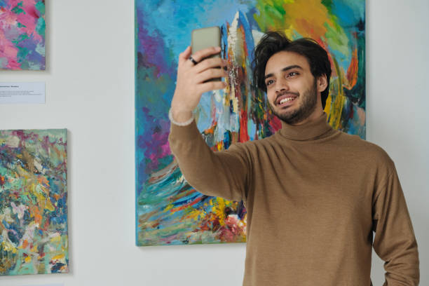 istock Man making selfie against painting 1495956288