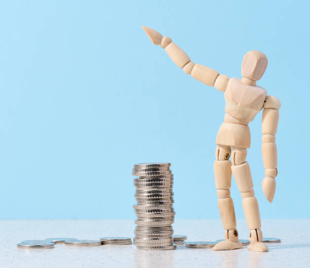 istock Wooden mannequin and a stack of coins on a blue background. Business indicators growth concept, income growth 1495957573