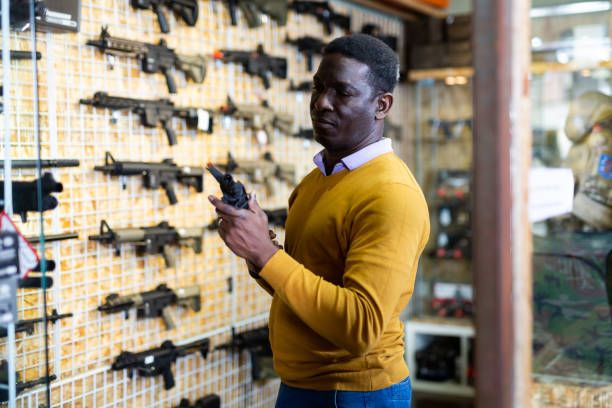 istock Man choosing assault rifle in arms shop 1495963162