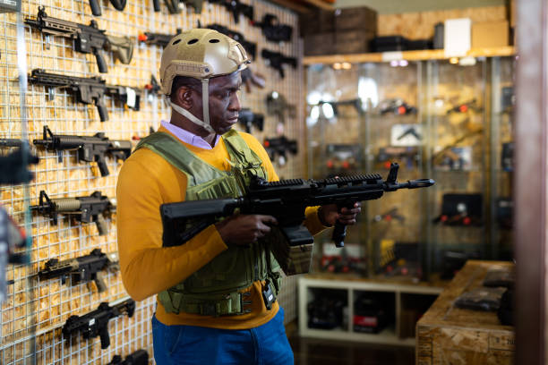 istock Man in armor vest selecting machine gun in weapon shop 1495963172