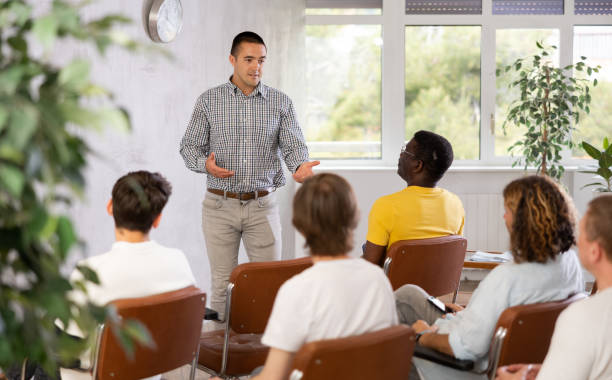 istock Young man teacher reading lecture for a group of guys 1495963524