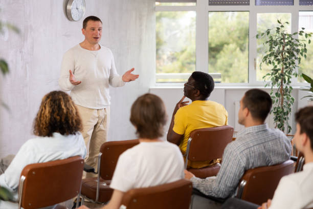 istock Middle-aged man teacher reading lecture for a group of guys 1495963525