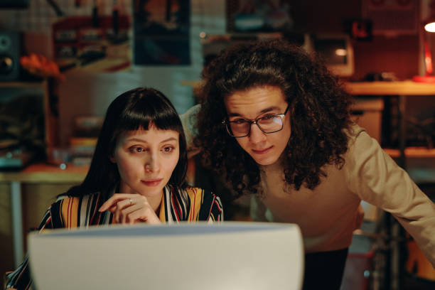 istock Couple of friends working on computer in team 1495965950