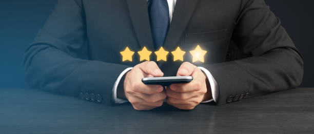 istock Man holding smartphone device and touching screen with five star rating feedback 1495966905