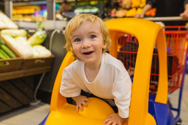 Small blonde child boy in toy car.