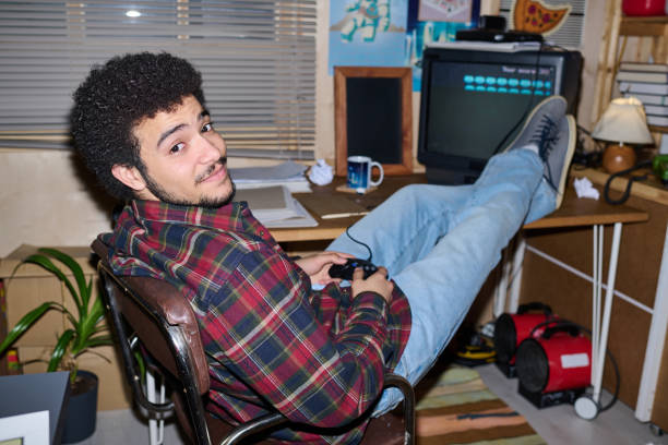 Young guy playing video game Portrait of young guy playing video game in garage during his leisure time inside of flash stock pictures, royalty-free photos & images