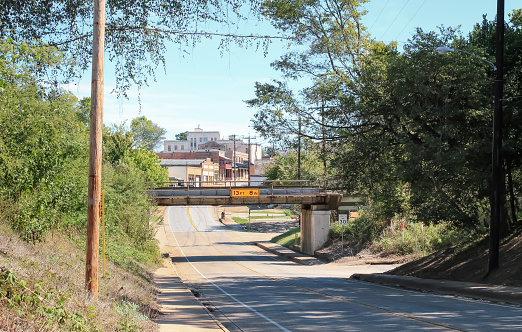 A view of the townscape with a railroad bridge and a winding road in Crockett, Texas