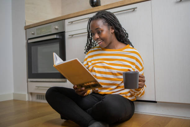 istock Happy woman reading book at home 1495981148