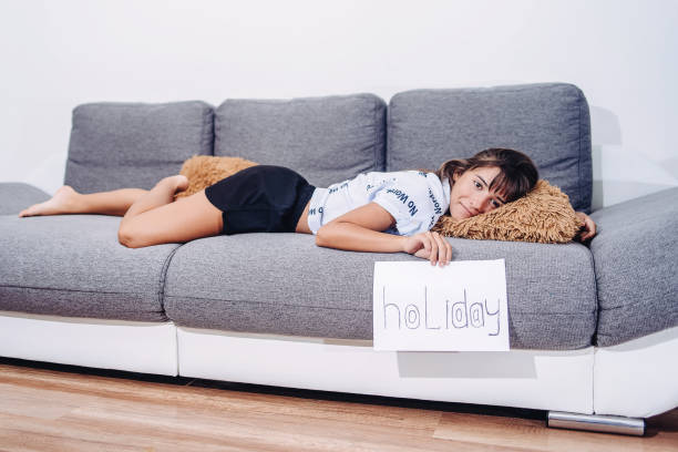 Young girl relaxing and feeling lazy on weekend.Day off work concept.Daydreams, peace of mind concept.Portrait, happy woman and relax on sofa on day off, break and peaceful rest in home. Comfortable, freedom and happiness of smile girl . concepto de día libre en el trabajo. soñar despierto, concepto de tranquilidad. retrato, mujer feliz y relajarse en el sofá en el día libre, descanso y descanso tranquilo en casa. cómoda, libertad y felicidad de chica sonrisa. chica joven relajándose