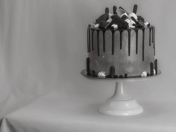 blue frosted icing cake with dark chocolate icing and mixed sweets as topping isolated on white background