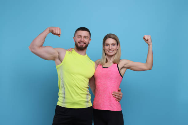 istock Athletic people showing muscles on light blue background 1495985705