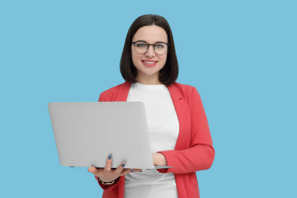 istock Happy young intern with laptop on light blue background 1495985872
