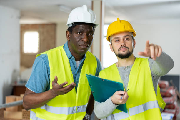 istock Two builders discussing working plan in apartment during repair works 1495990473