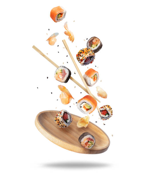 istock Various fresh sushi rolls with ginger falling on a wooden plate 1495990558