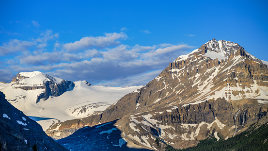 Rugged mountain peaks and snow mass in the Canadian Rockies at sunrise