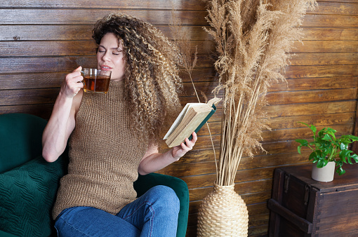 Young woman reading a book and drinking tea