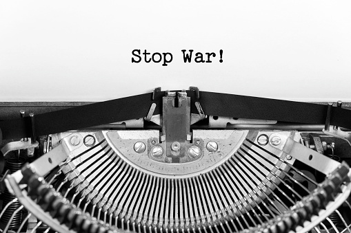 Stop War phrase closeup being typing and centered on a sheet of paper on old vintage typewriter mechanical.