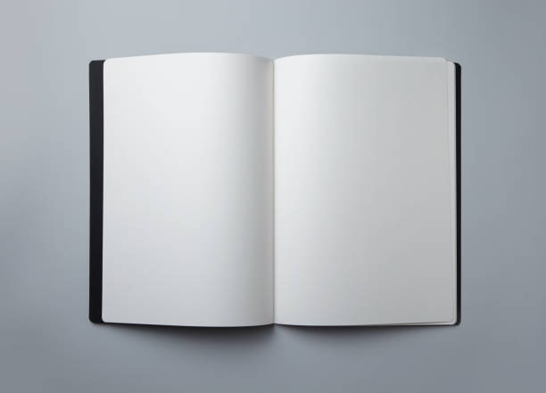 istock Open blank book with black cover isolated on white background. Top view. 1495995093