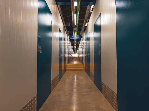 A deep corridor with closed blue doors on either side