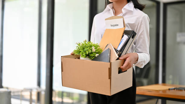 istock A female office worker holds her cardboard box with stuff and her resignation letter. 1496002911