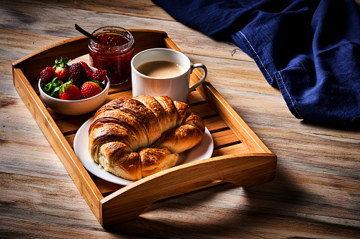 Food theme series: Breakfast with cup of coffee, croissants, marmalade, and fruits in a serving tray