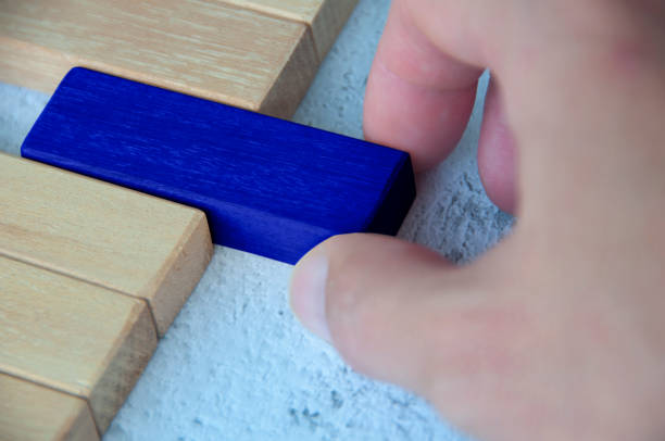 istock Hand pulling blue wooden block from other wooden block with customizable space for text. Copy space. 1496009981