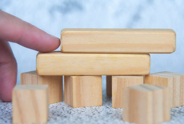 istock Hand pushing a wooden block from other stacked wooden block. Customizable space for text. Copy space. 1496009995