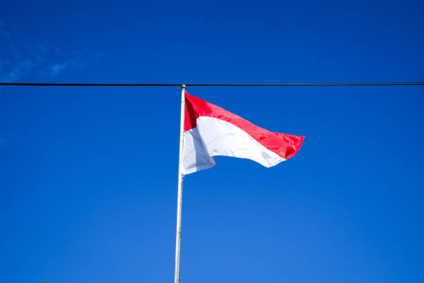 istock Indonesian flag with blue sky as background 1496011360