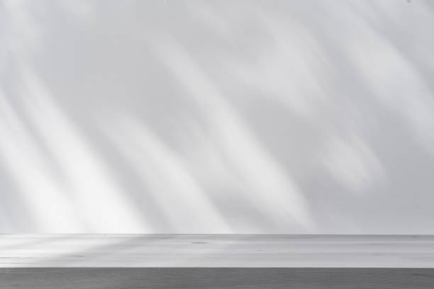 istock Shadow of palm leave with white wooden table and copy space 1496012854