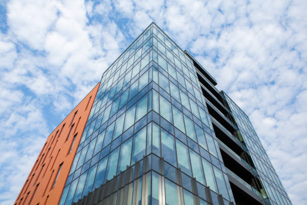Modern office building with glass facade and blue sky.