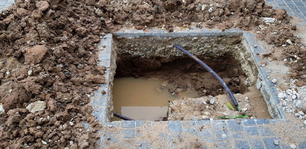 istock Hole for installation pillar or pole on cement ground with water and black wire cable at construction site and no strict and make symbol to tell danger area. 1496027460