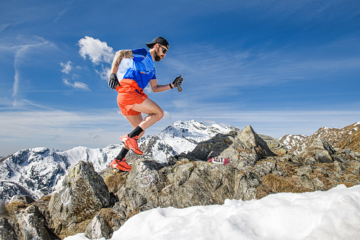 A trail runner trains uphill running in the mountains