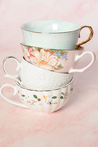 Pretty tea cups on pink background