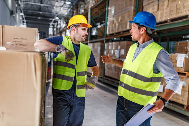 istock Manual worker talking to his inspector in distribution warehouse. 1496033070