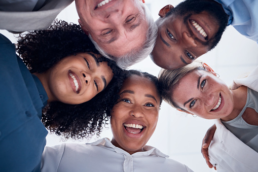 bottom view. diverse multiracial coworkers of different ages standing in a circle at sunset - business people concept -