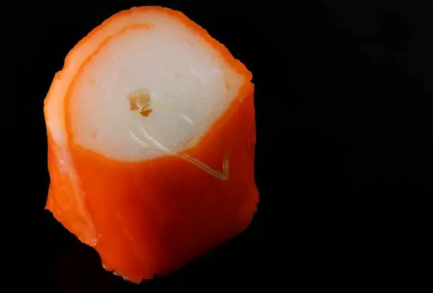 Photo of Anisakis parasitic worms in a piece of fresh fish or Sushi