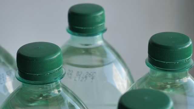 Closeup view of long shelf life plastic clean water bottles with a expiration date up to 2024 rotates 4K video