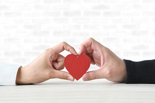 Couple's hand holding heart object together