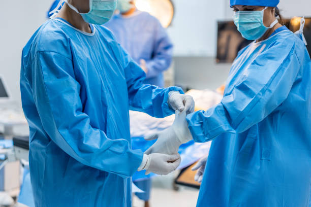 istock Professional doctors performing surgical operation in operating room. Attractive specialist medic surgeon medical team working and operation sick patient on intensive care patient in hospital ward. 1496049391