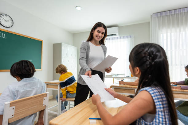 istock Group of student learn with teacher in classroom at elementary school. Attractive beautiful female instructor master explain and educate young children with happiness and fun activity at kindergarten. 1496049637