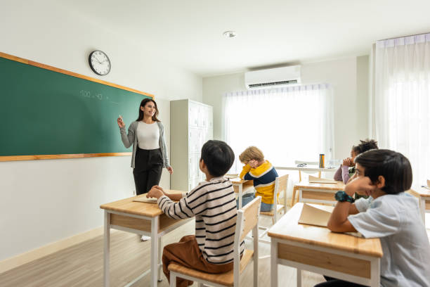 istock Group of student learn with teacher in classroom at elementary school. Attractive beautiful female instructor master explain and educate young children with happiness and fun activity at kindergarten. 1496049660