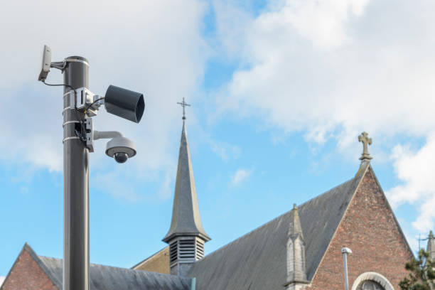 externe videoüberwachungskamera auf dem hintergrund der kirche. cctv - surveillance history social issues horizontal stock-fotos und bilder