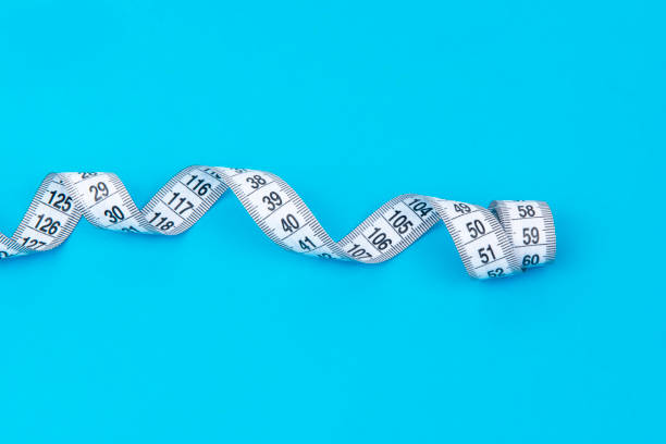 istock Spiral centimeter tape measure on background waist concept 1496052880