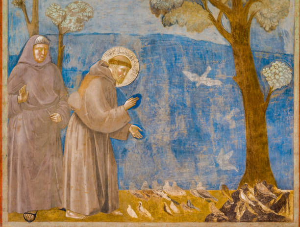 Giotto's fresco of St. Francis speaking to the birds in the Basilica of San Francesco in the heart of Assisi The beautiful fresco painted by Giotto depicting Saint Francis talking to birds inside the Basilica Superiore di San Francesco (Upper Basilica of Saint Francis), in the medieval heart of Assisi, in Umbria. Giotto painted a series of great frescoes along the walls of the single nave of the Basilica between 1292 and 1305, depicting the Stories of St. Francis, from his vocation to his death. Built in the Italian Gothic style starting from 1228 and completed in 1253, the Basilica preserves the mortal remains of the Saint of the Poor since 1230. The construction of the Basilica consists of a Lower Basilica and an Upper Basilica, perfectly integrated. Over the centuries Assisi and the spirituality of its sacred places have become a symbol of peace, a point of reference for tolerance and solidarity between peoples and between the different confessions of the world. The Umbria region, considered the green lung of Italy for its wooded mountains, is characterized by a perfect integration between nature and the presence of man, in a context of environmental sustainability and healthy life. In addition to its immense artistic and historical heritage, Umbria is famous for its food and wine production and for the high quality of the olive oil produced in these lands. Since 2000 the Basilica and other Franciscan sites of Assisi have been declared a World Heritage Site by UNESCO. Image in high definition format. medieval fresco stock pictures, royalty-free photos & images