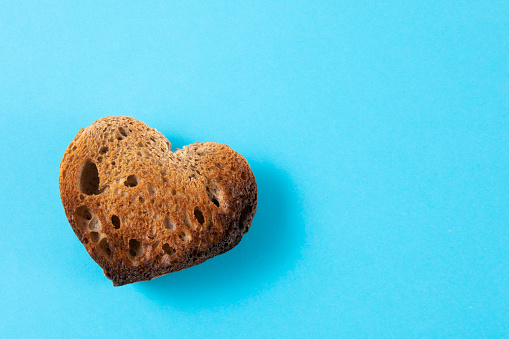 Heart shaped bread on blue background