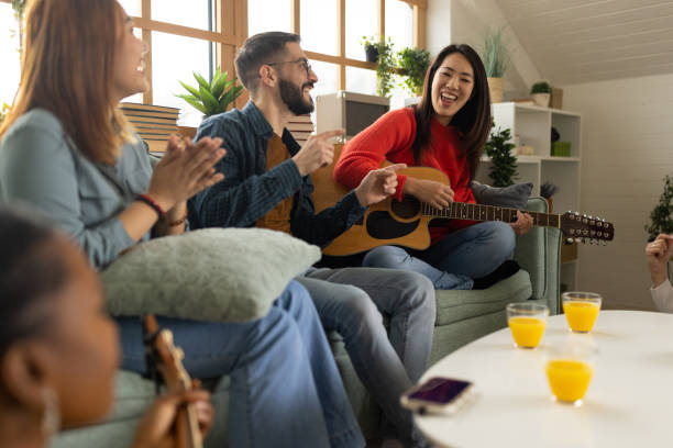 istock Group of friends relaxing and playing instruments at home 1496054126