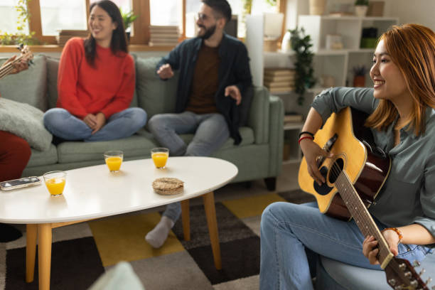 istock Group of friends playing instruments and singing at home 1496054763