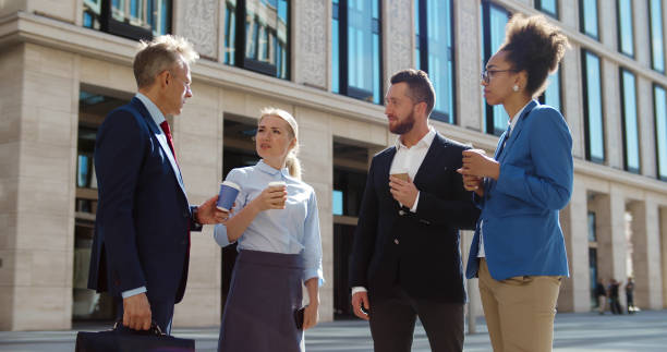 istock Diverse business colleagues outside office drinking coffee and chatting 1496057732