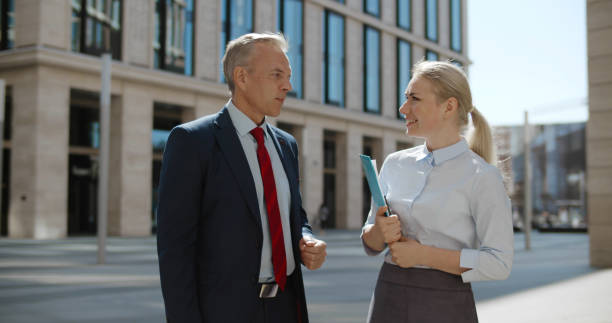 istock Business colleagues discussing new project outside office in urban setting. 1496058773